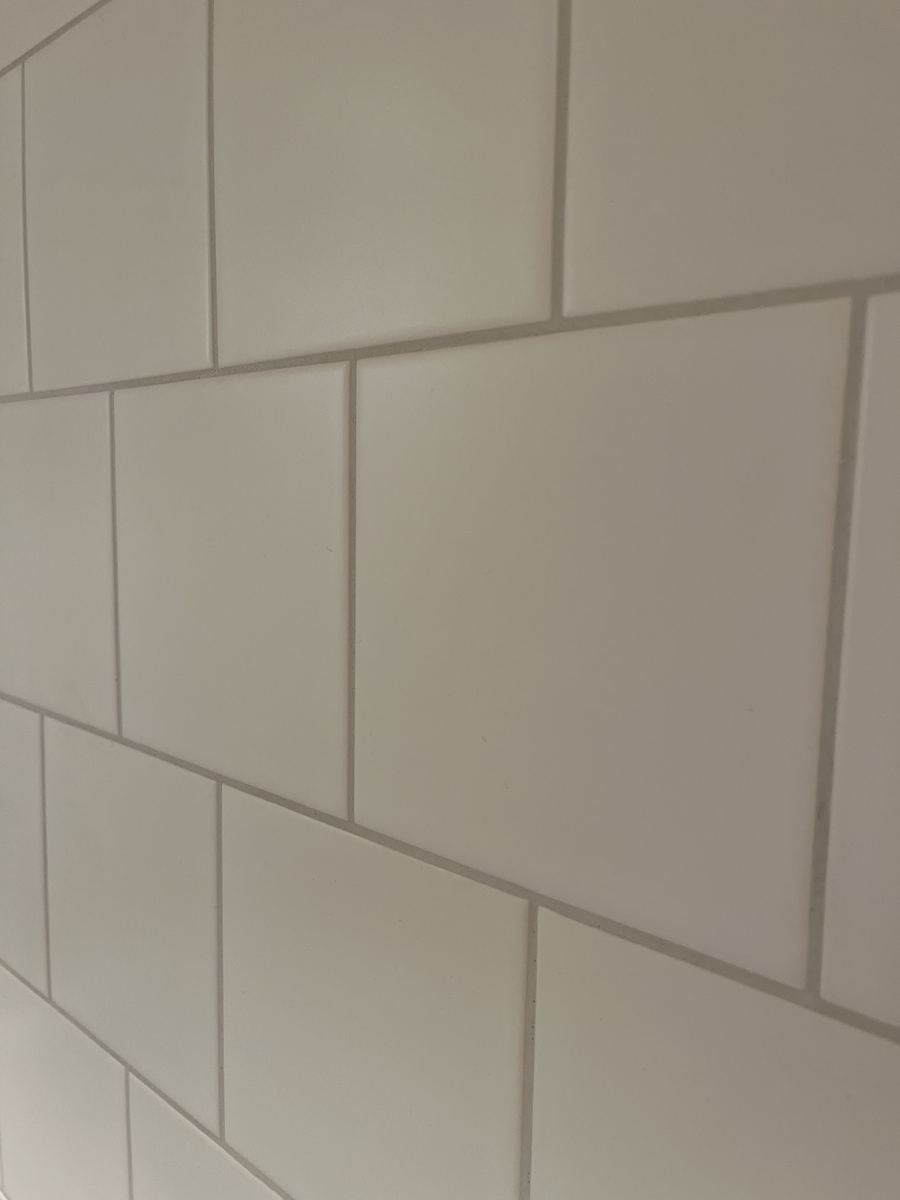 Närbild på vita väggplattor med raka fogar
